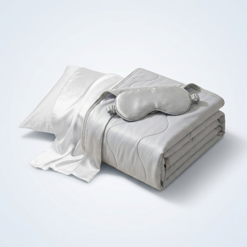 Ice-silk cooling blanket, cooling pillow and sleep mask on a bed