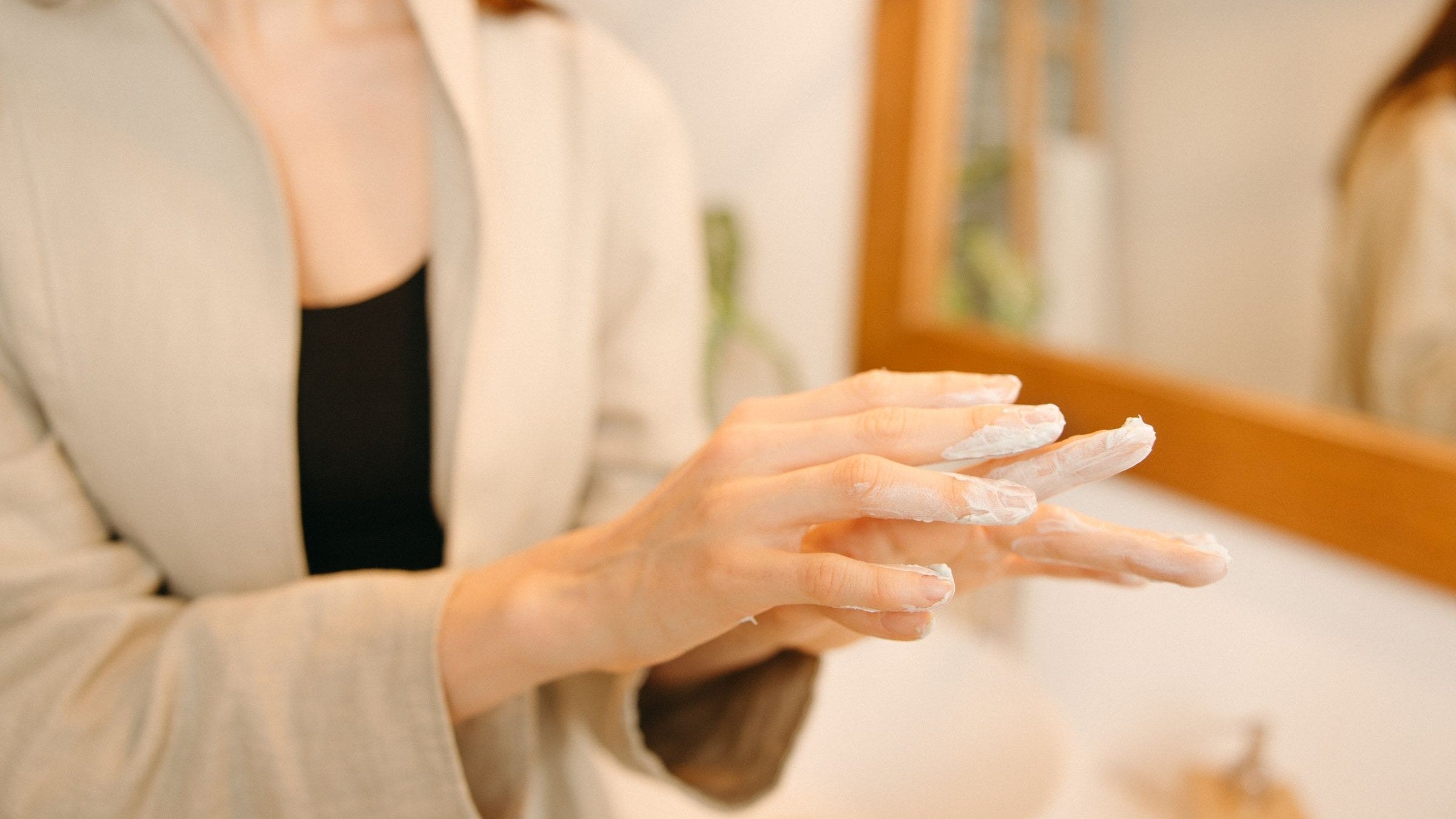 Moisturiser being smoothed onto the back of a hand in daylight